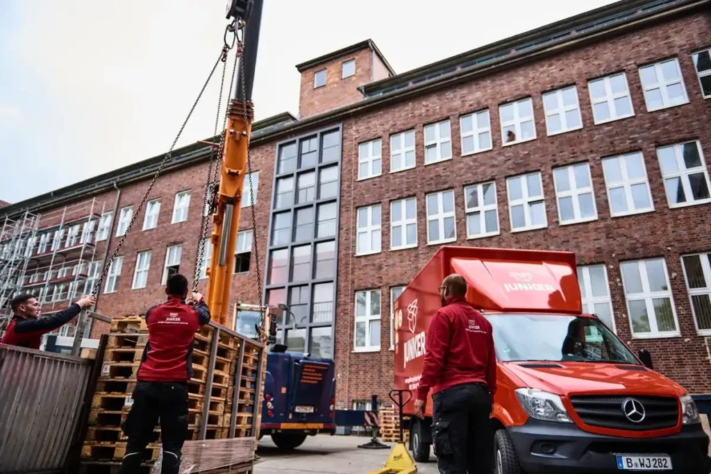 Umzugsfirma Junker Berlin – professionelle Umzugshelfer mit Möbellift und LKW bei einem Firmenumzug