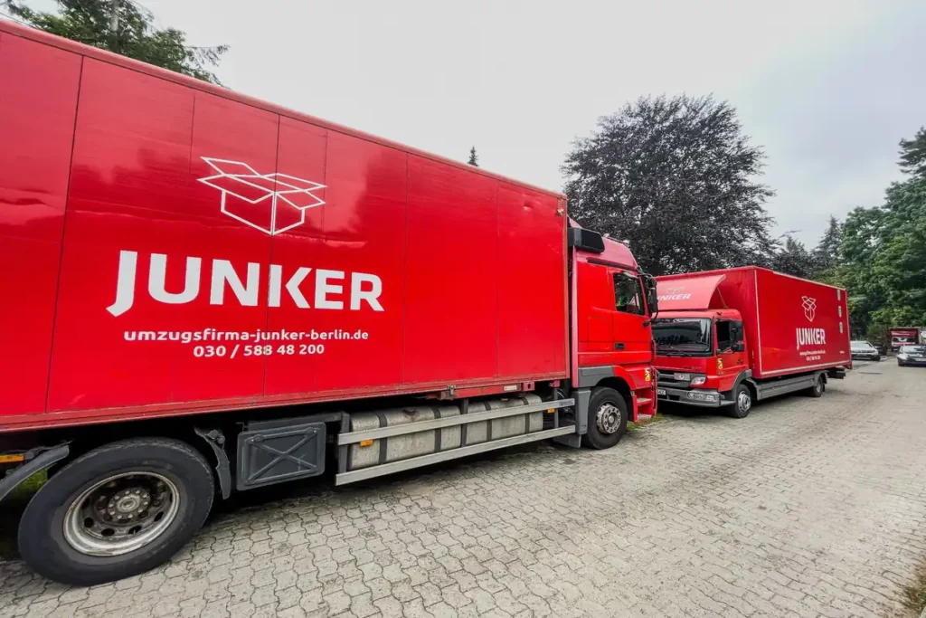 Zwei rote Umzugs-LKW der Umzugsfirma Junker in Berlin, bereit für einen professionellen Umzug