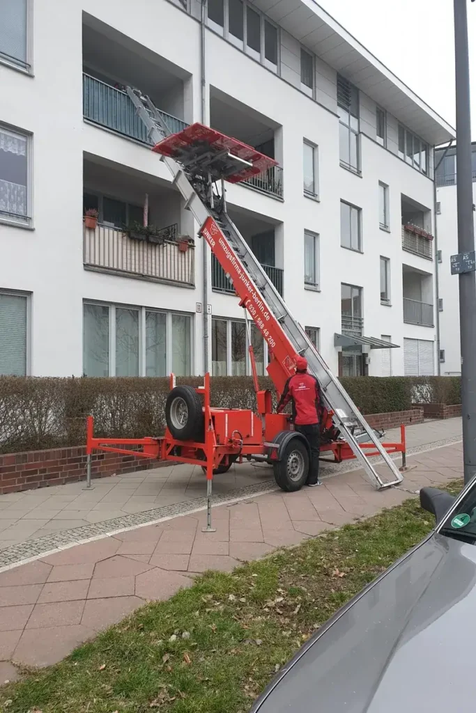 Möbellift der Umzugsfirma Junker im Einsatz vor einem Mehrfamilienhaus – effizienter Möbeltransport über den Balkon.