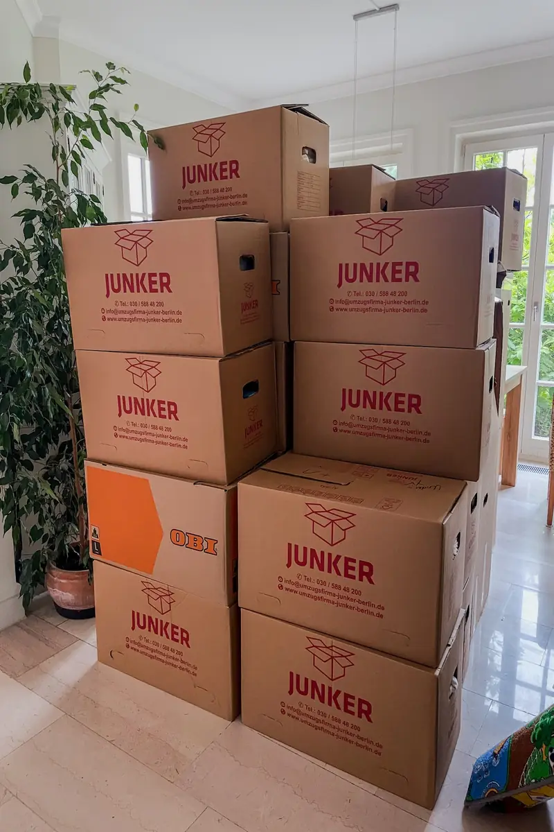 Gestapelte Umzugskartons der Umzugsfirma Junker in einer Wohnung – bereit für weitere Seniorenumzüge.