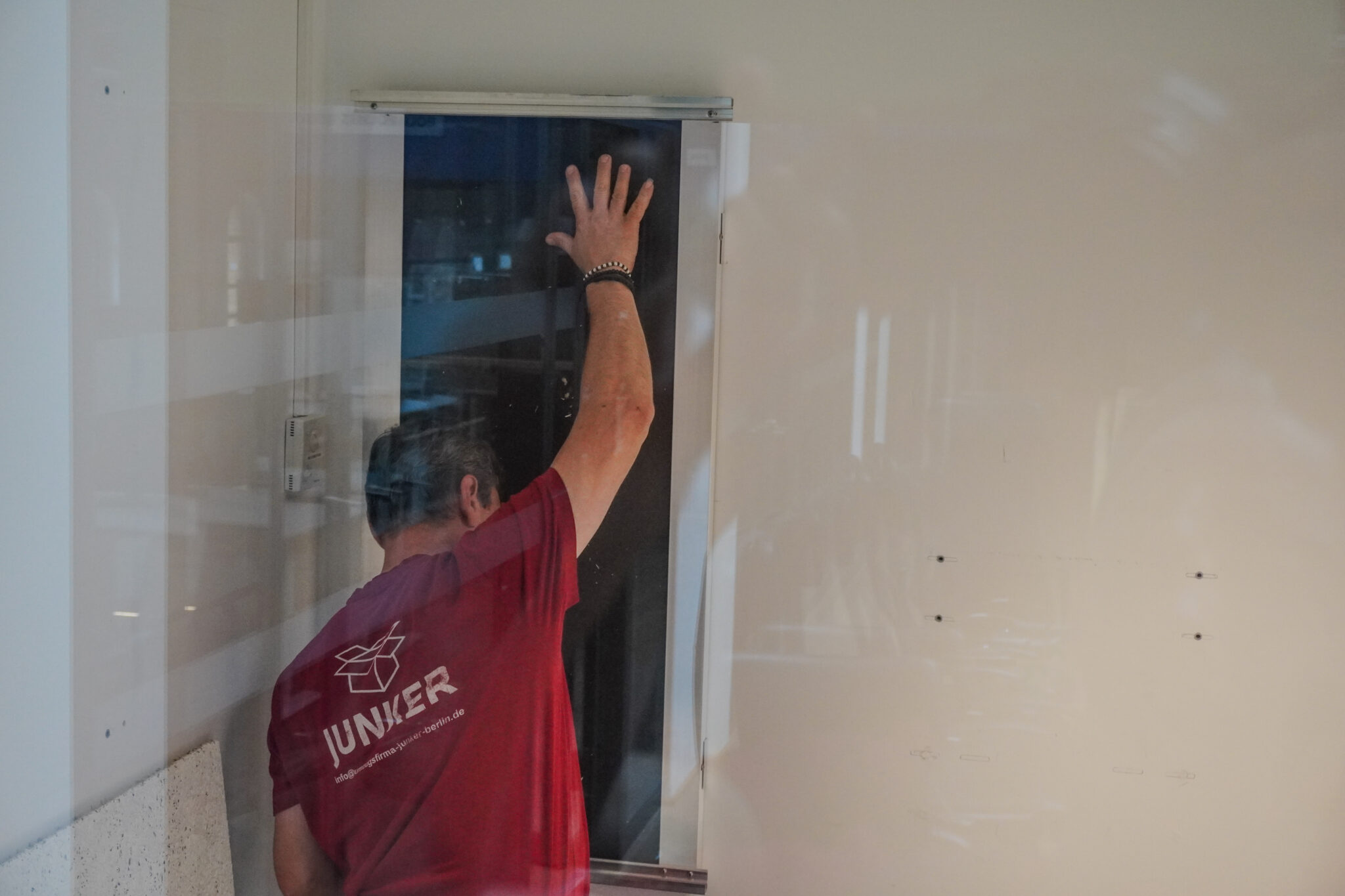 Mitarbeiter der Junker Umzugsfirma trägt ein Möbelstück durch einen engen Innenbereich.